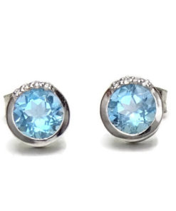 Preciosos y vistosos pendientes de oro blanco de 18k con 8 diamantes que suman 0.04cts y 2 topacios azules. Tamaño del pendientes; 6mm de diámetro y cierre presión.