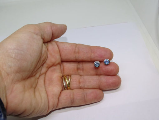 Preciosos y vistosos pendientes de oro blanco de 18k con 8 diamantes que suman 0.04cts y 2 topacios azules. Tamaño del pendientes; 6mm de diámetro y cierre presión. - Imagen 3