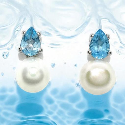 Pendientes con 2 topacios azules engastados con 4 garras en oro blanco de 18k y 2 perlas cultivadas de 7mm.